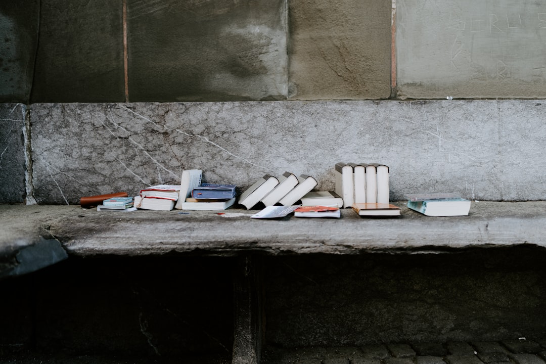 books on white table beside gray concrete wall