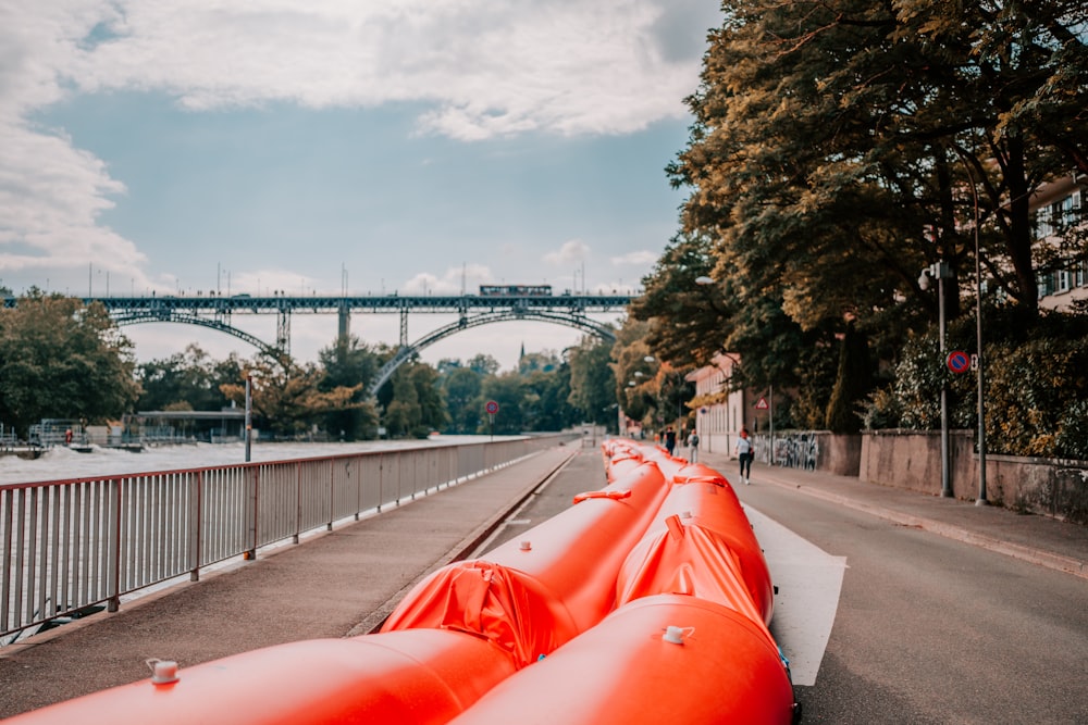 red car on gray concrete bridge under white clouds during daytime