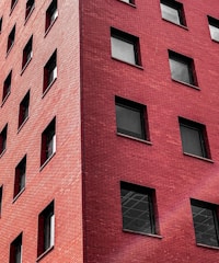 Image showing a commercial building facade made with red bricks and large windows.