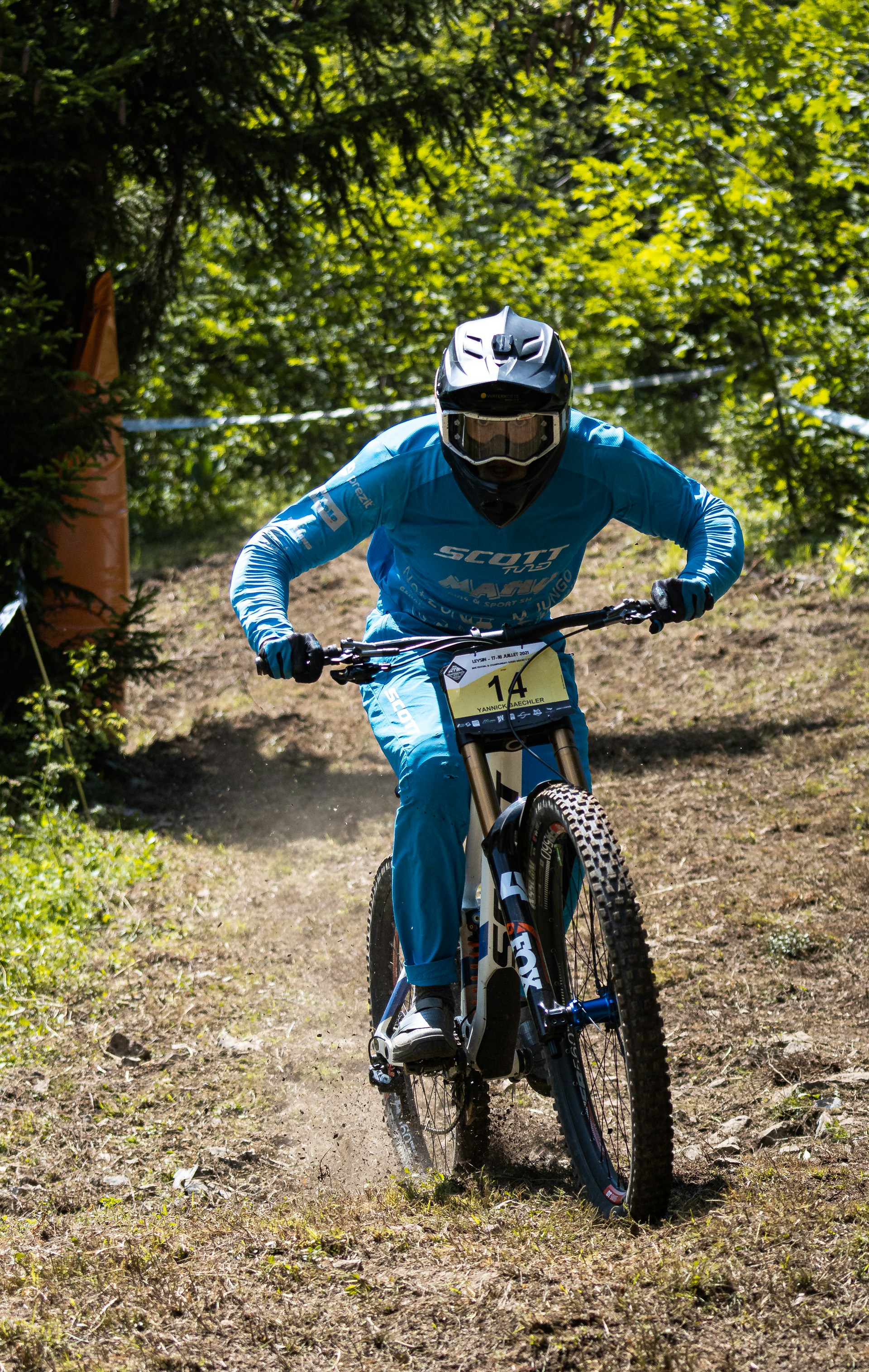 man in blue and white jacket riding on red mountain bike during daytime