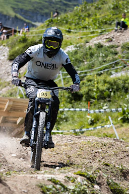 man in black and white motorcycle suit riding on black mountain bike during daytime