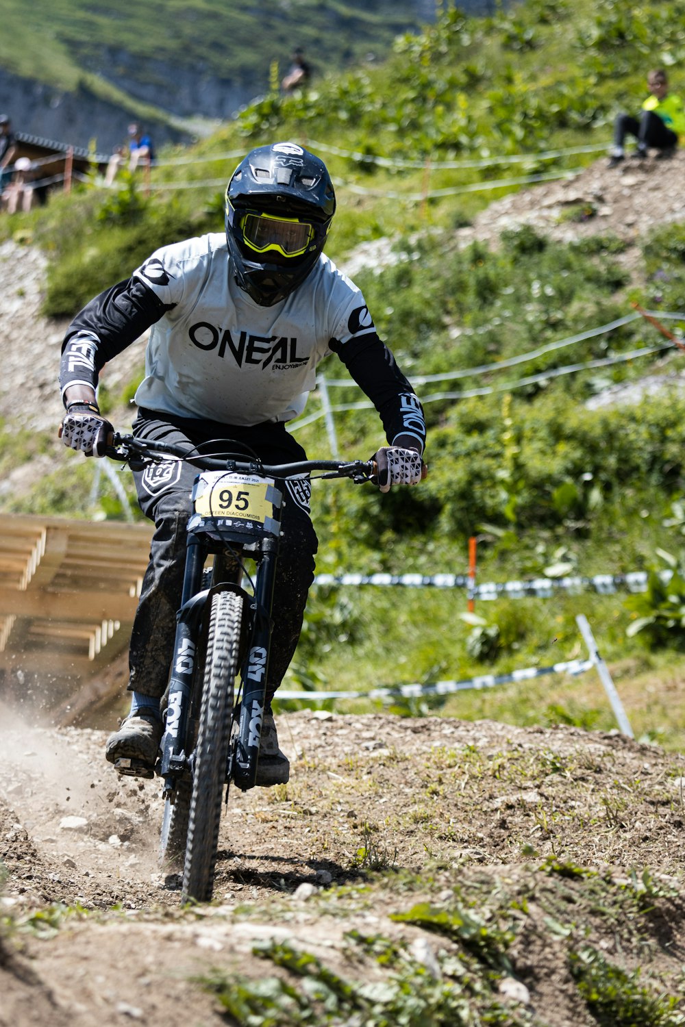 man in black and white motorcycle suit riding on black mountain bike during daytime