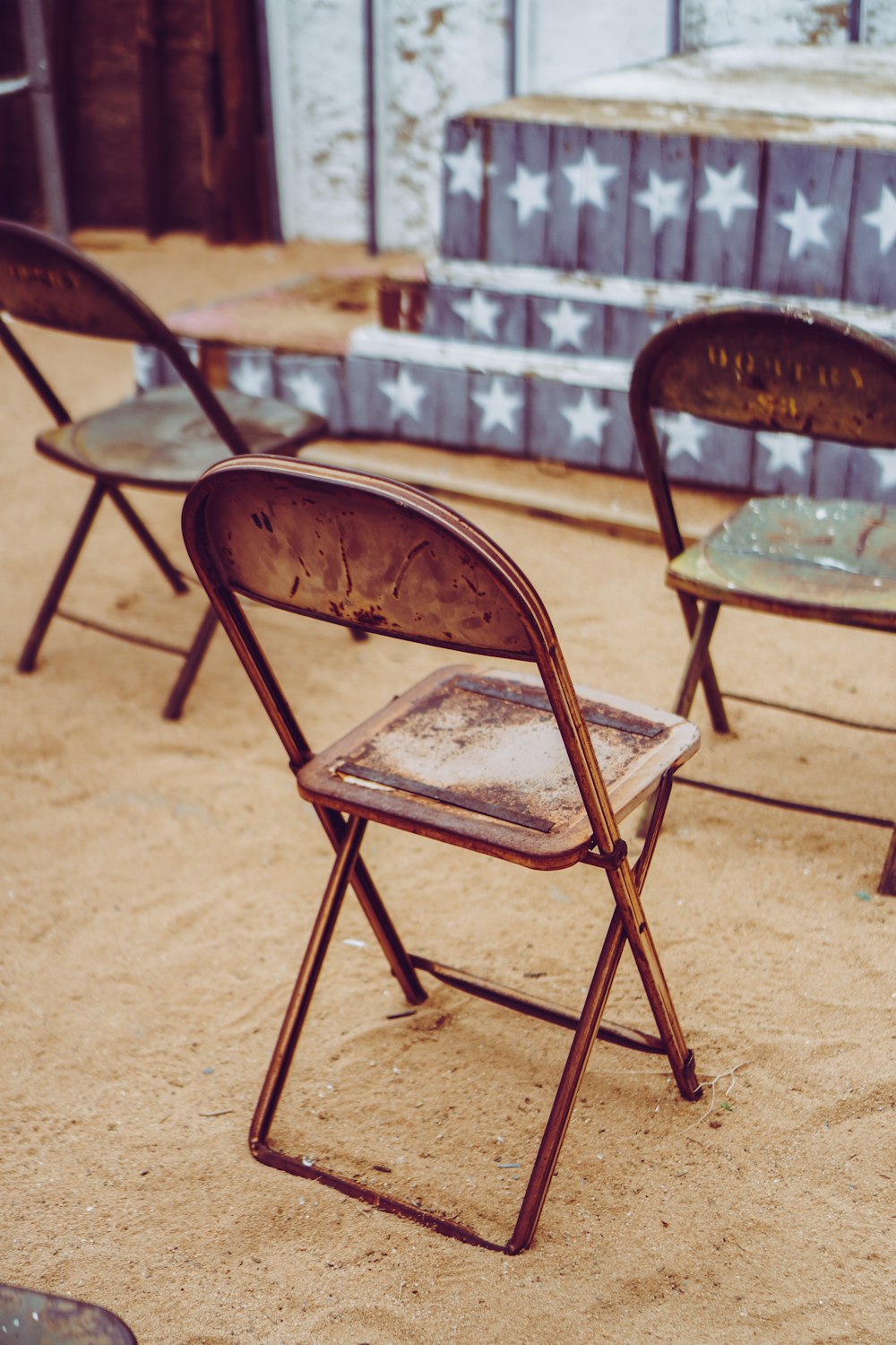 日中の茶色の砂浜の茶色の木製の折りたたみ椅子