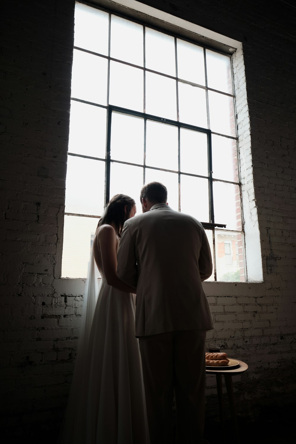 man and woman standing beside window during daytime