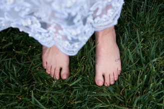 Woman walking barefoot on grass wearing a silver anklet with intricate design