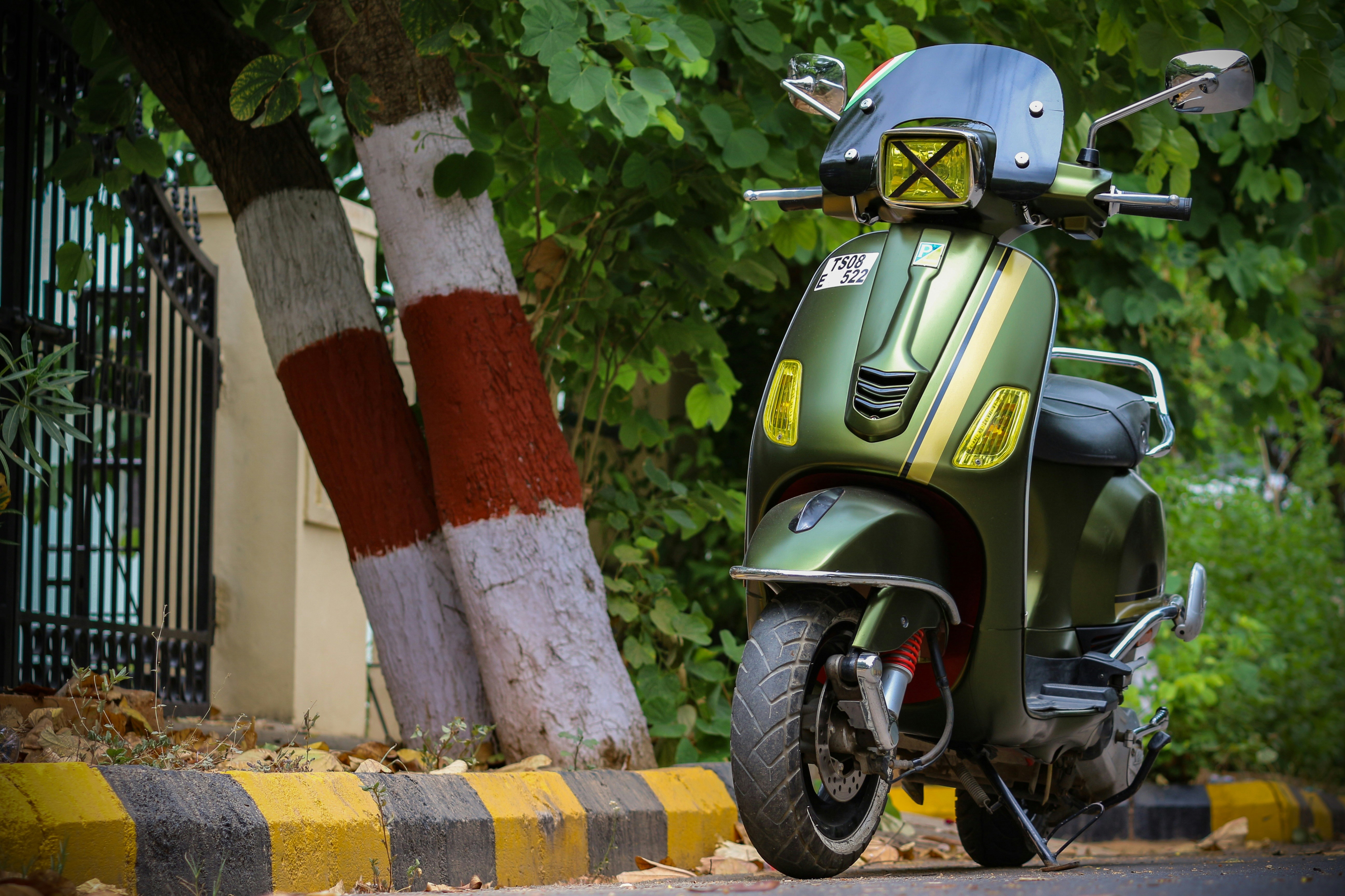 green and black motorcycle parked beside red and white post