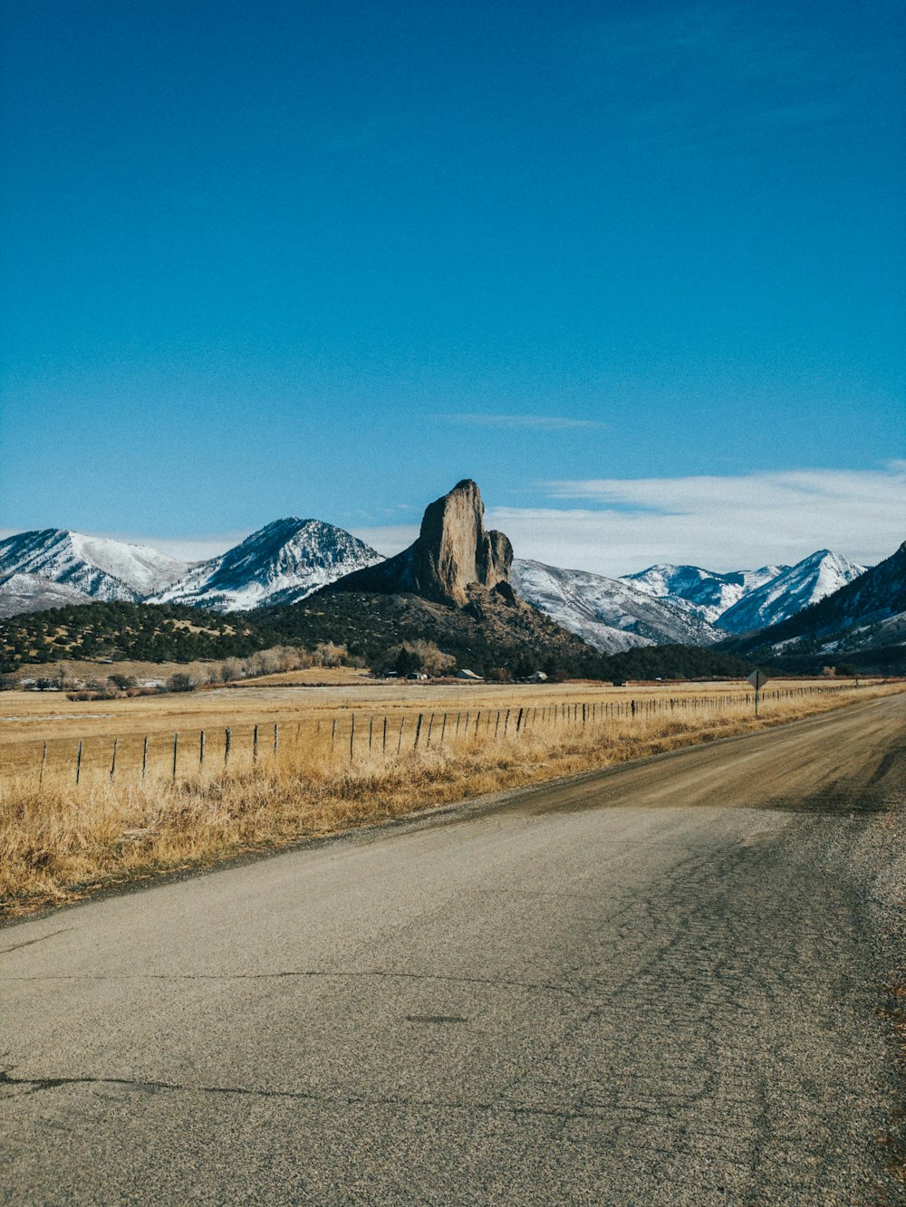 Carretera de asfalto gris cerca de las montañas bajo el cielo azul durante el día