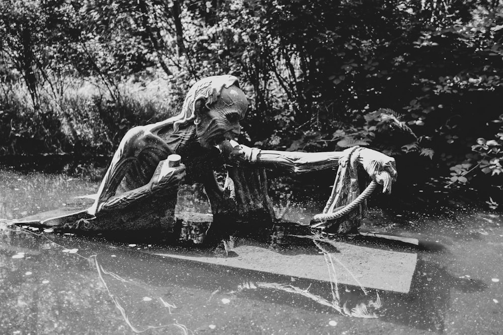 Photo en niveaux de gris d’une femme assise sur une chaise