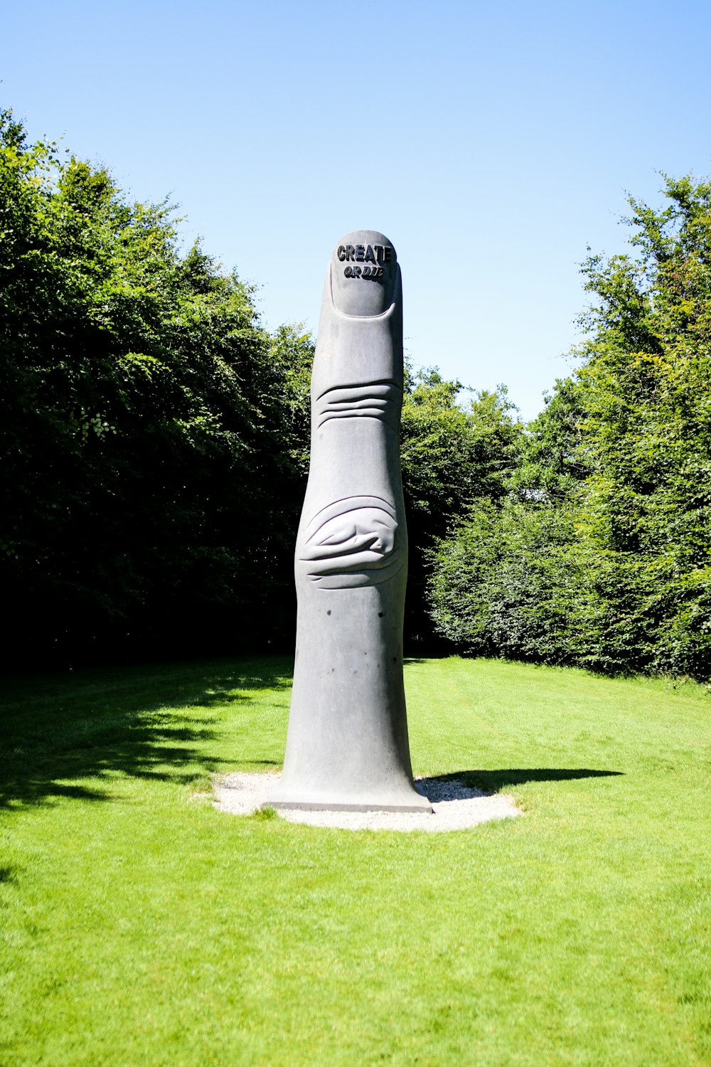 gray concrete statue on green grass field during daytime