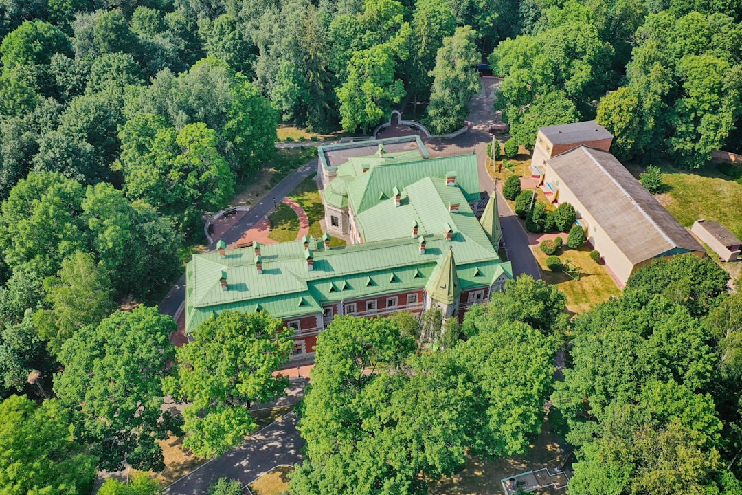 aerial view of green and brown building surrounded by green trees during daytime