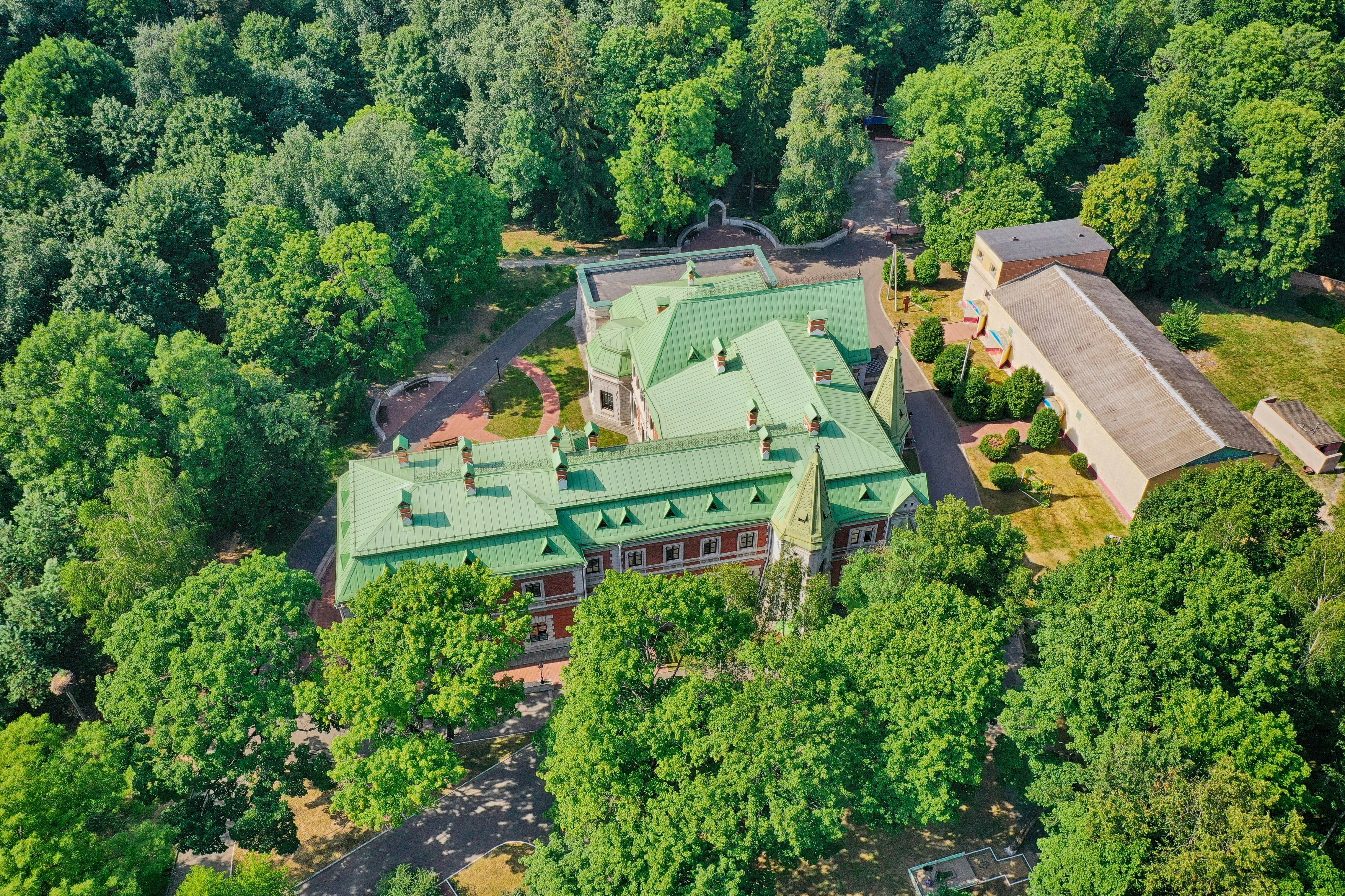 aerial view of green and brown building surrounded by green trees during daytime