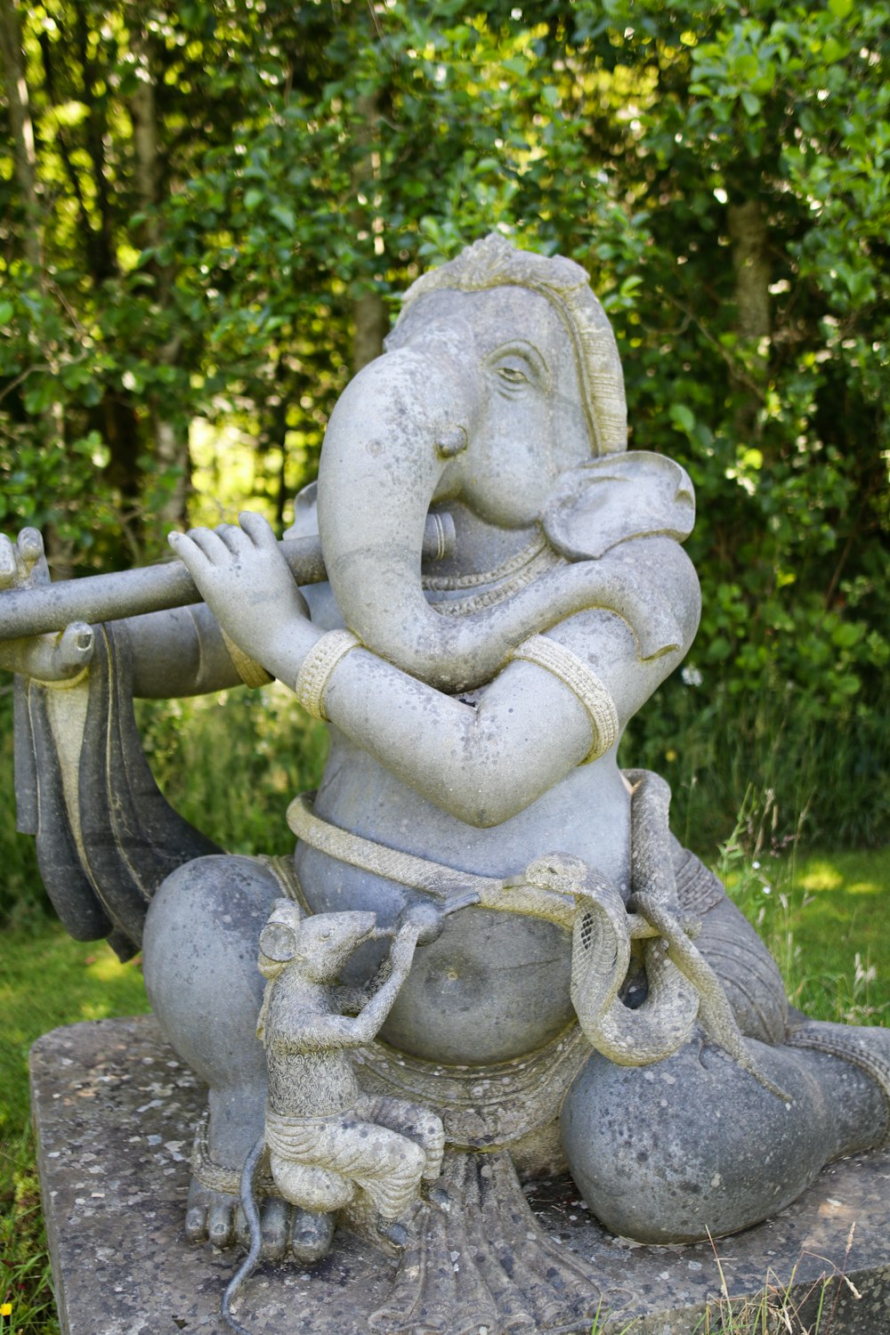 gray concrete statue near green trees during daytime