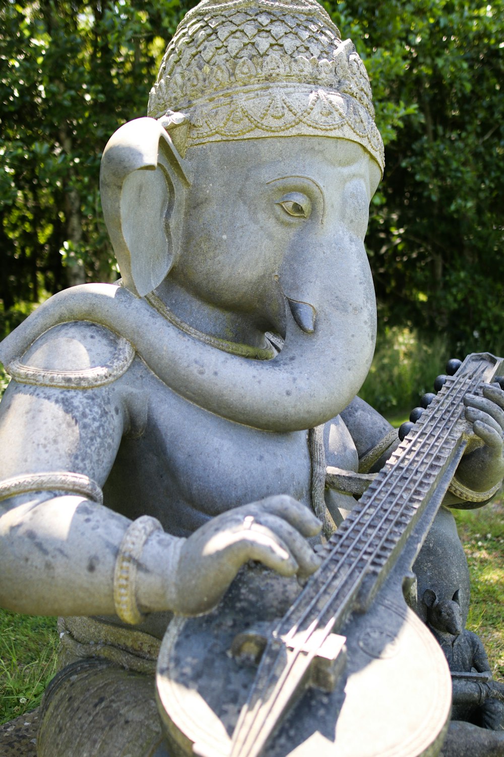 grey concrete statue near green trees during daytime