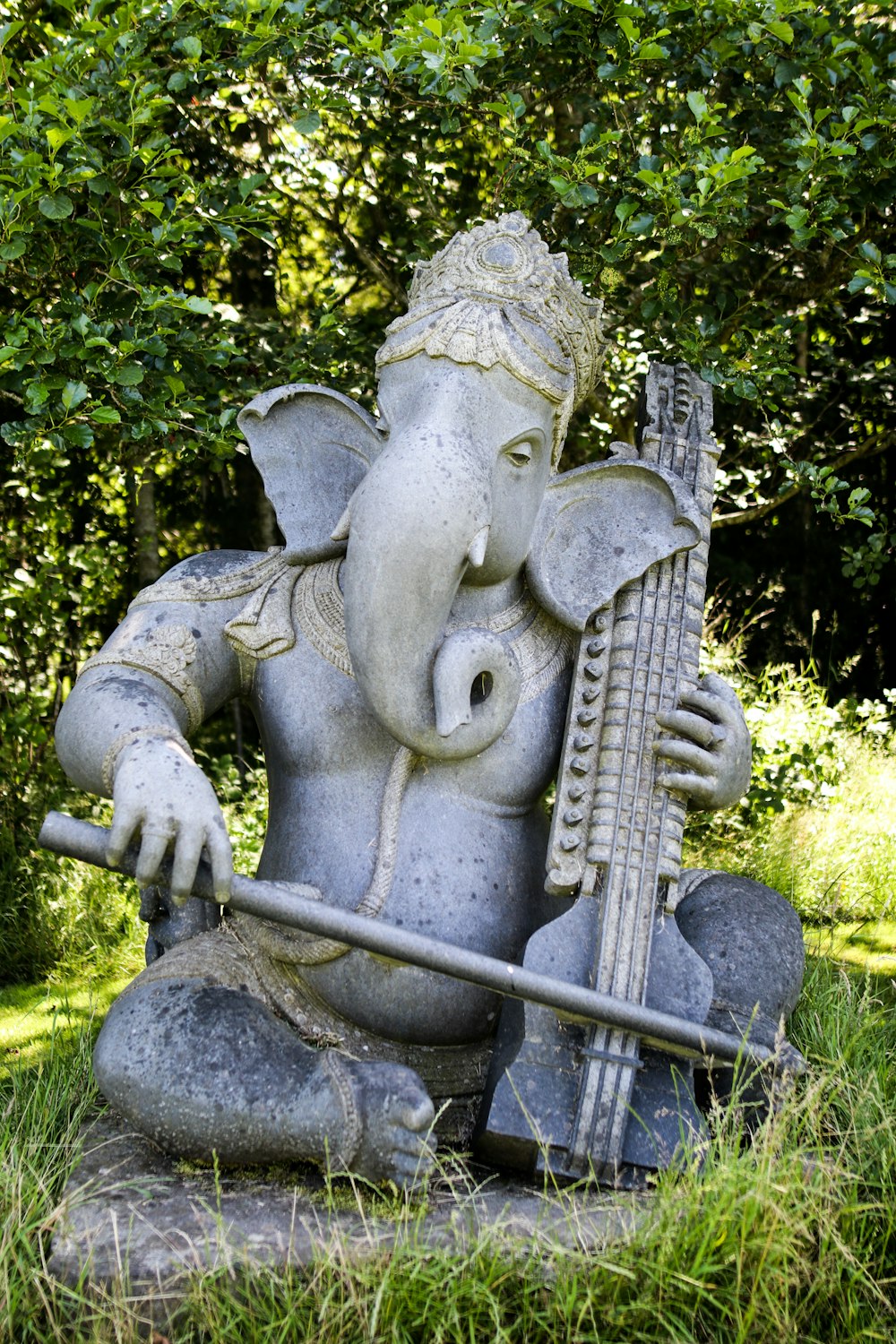 gray concrete statue near green trees during daytime