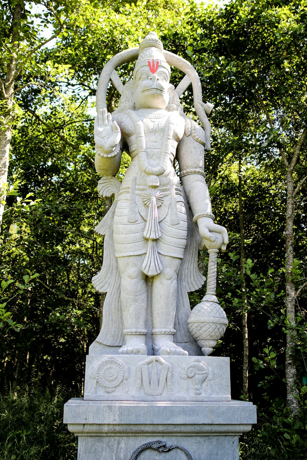 angel statue near green trees during daytime