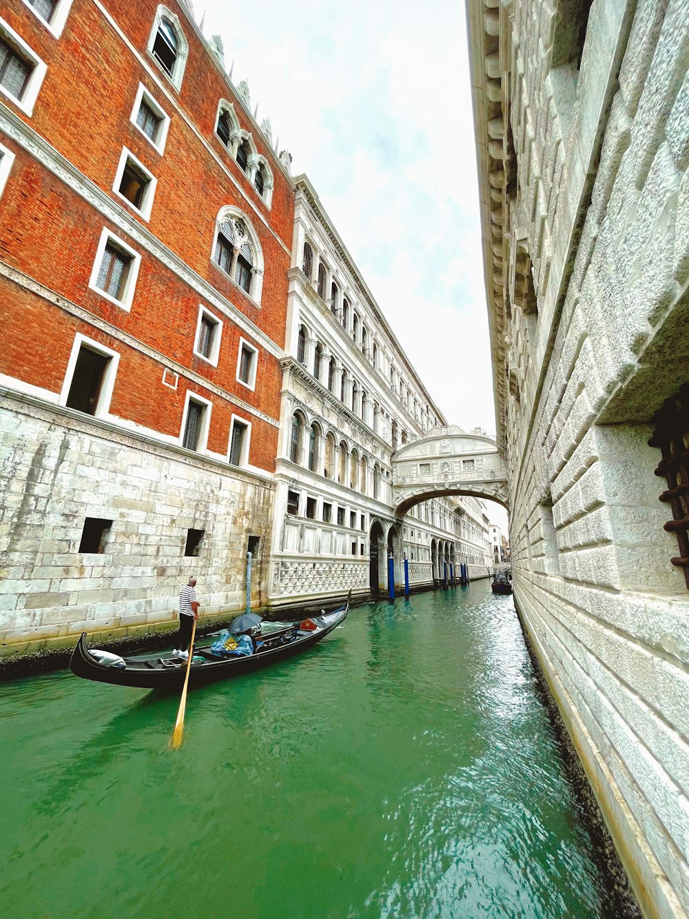 blue boat on river between concrete buildings during daytime