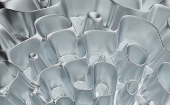 Complex, fluid-like structures with smooth, flowing contours. The translucent and slightly reflective surface gives a futuristic or abstract feel.