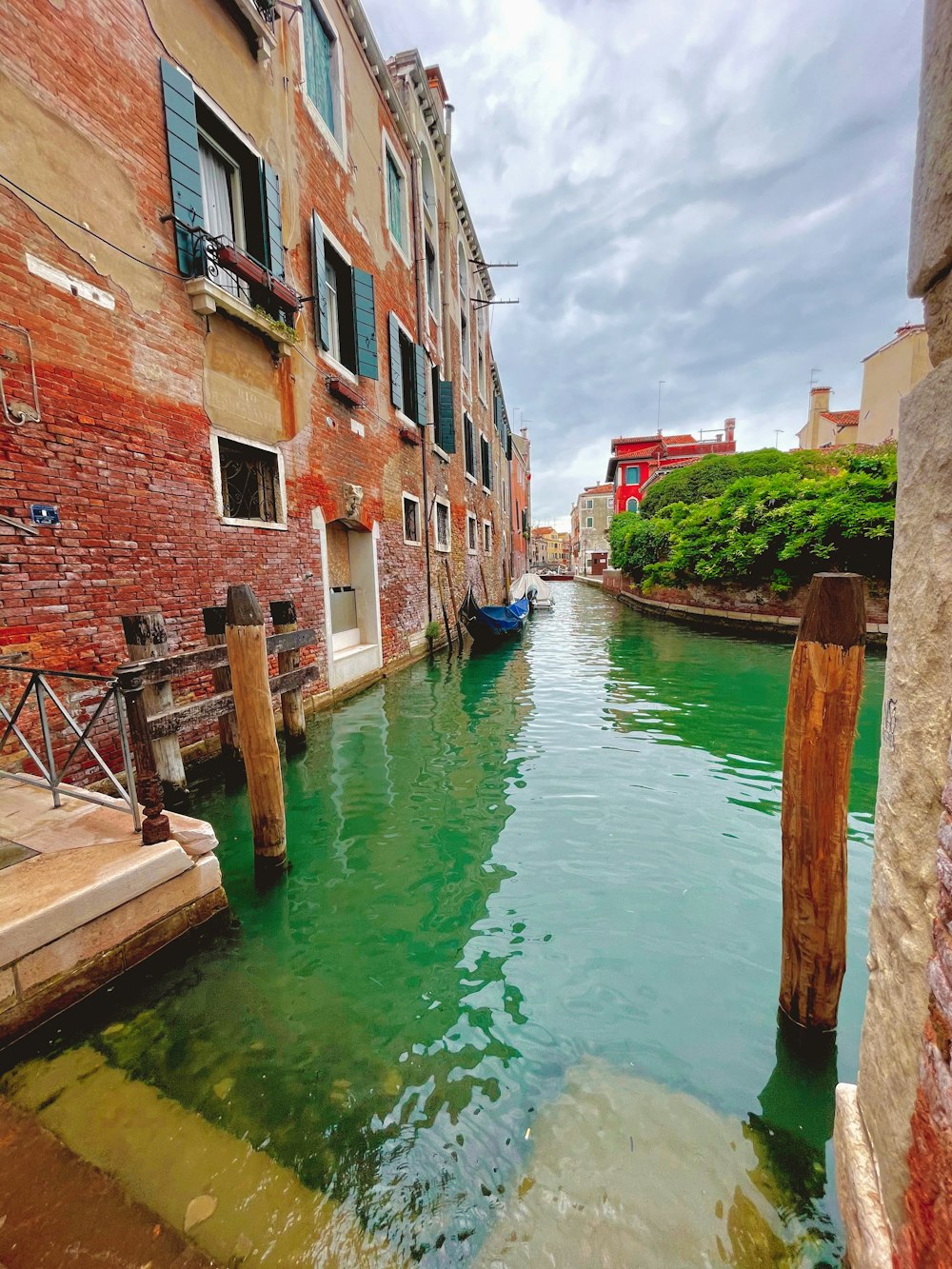 blue boat on water between brown concrete buildings during daytime