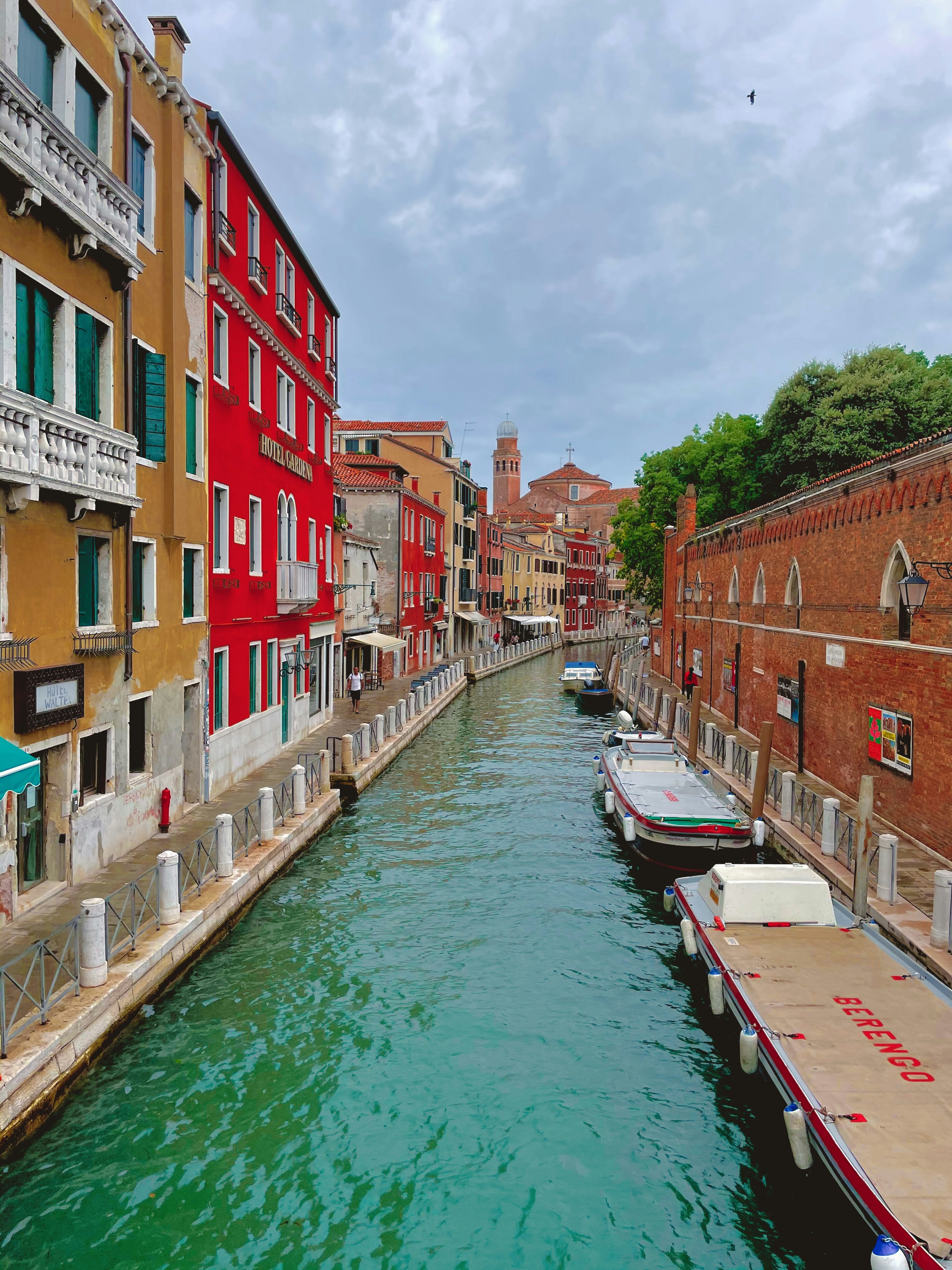 boat on river between buildings during daytime