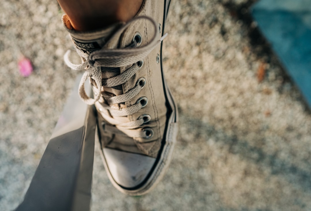 person wearing gray and white low top sneaker