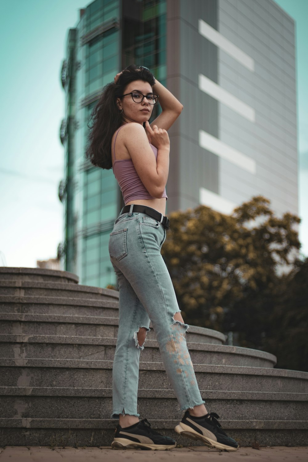 Woman in black sports bra and blue denim jeans standing on stairs during  daytime photo – Free Pants Image on Unsplash