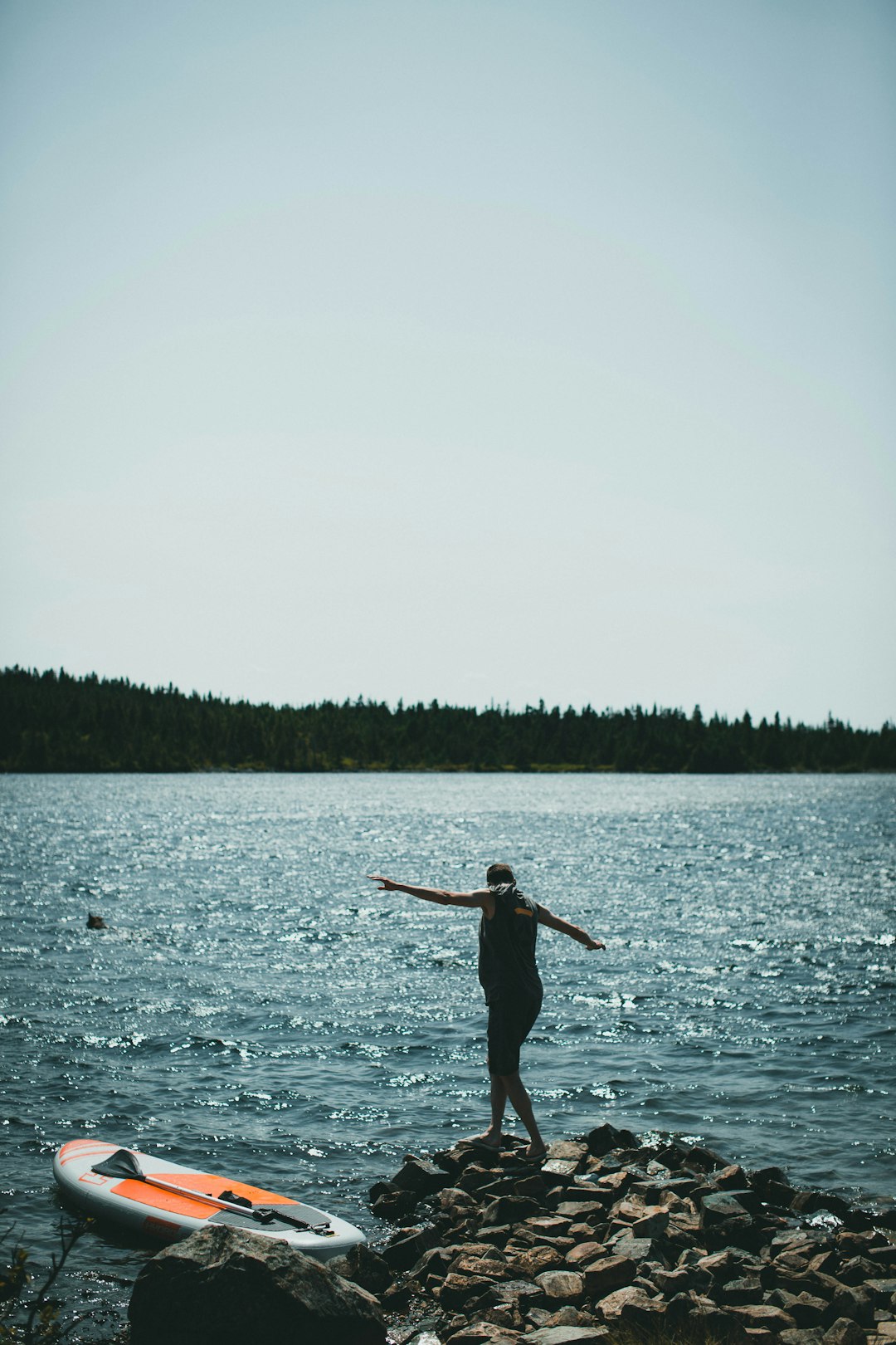 woman in black dress standing on body of water during daytime