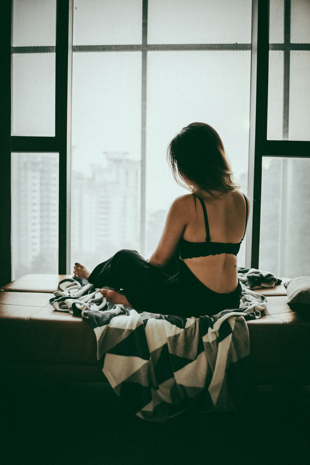 woman in black tank top sitting on bed