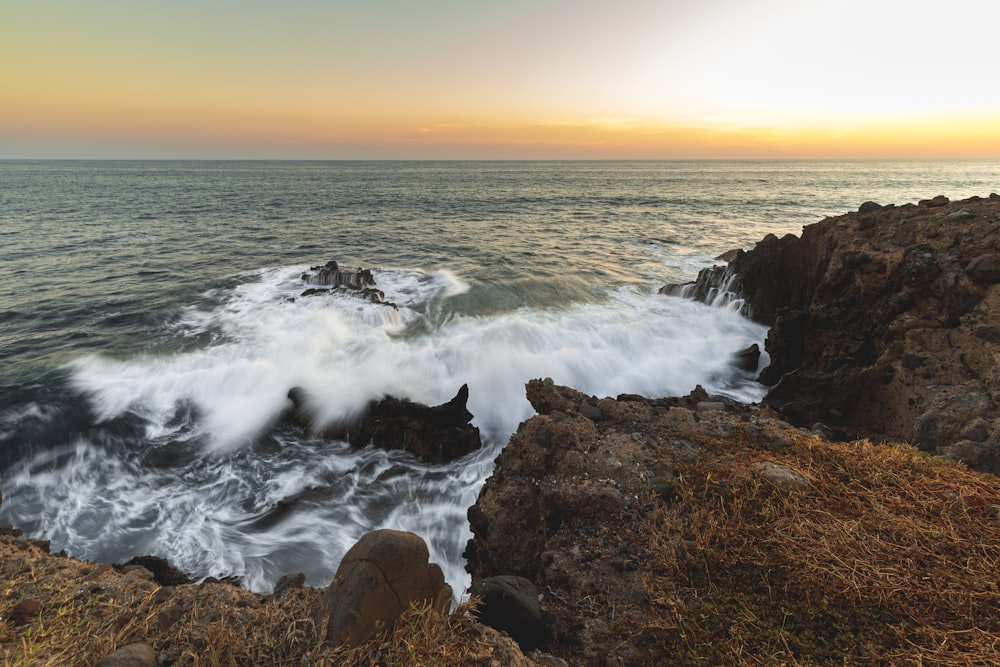 a large body of water sitting next to a rocky shore