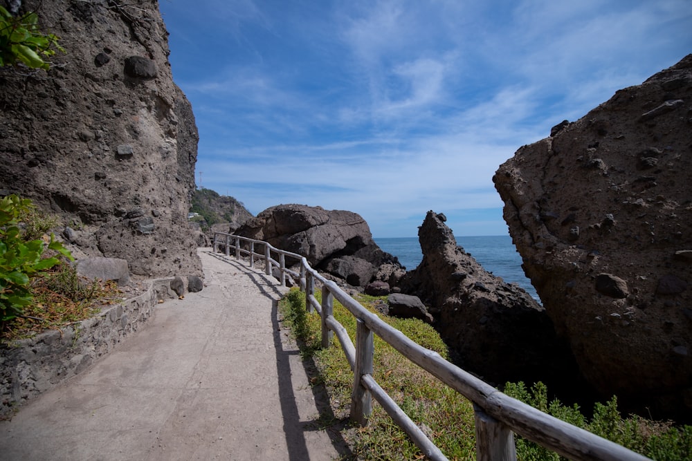 brown concrete pathway near brown rock formation during daytime