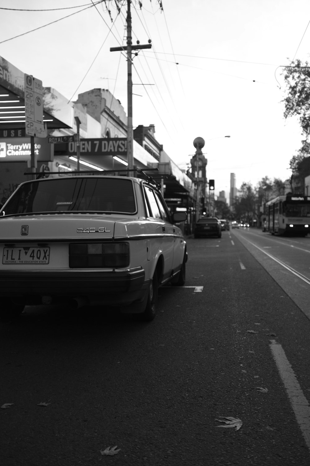 a black and white photo of a car parked on the side of the road