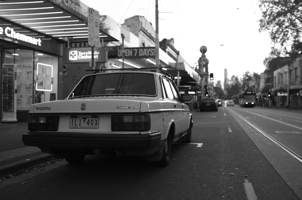 a black and white photo of a car parked on the side of the road