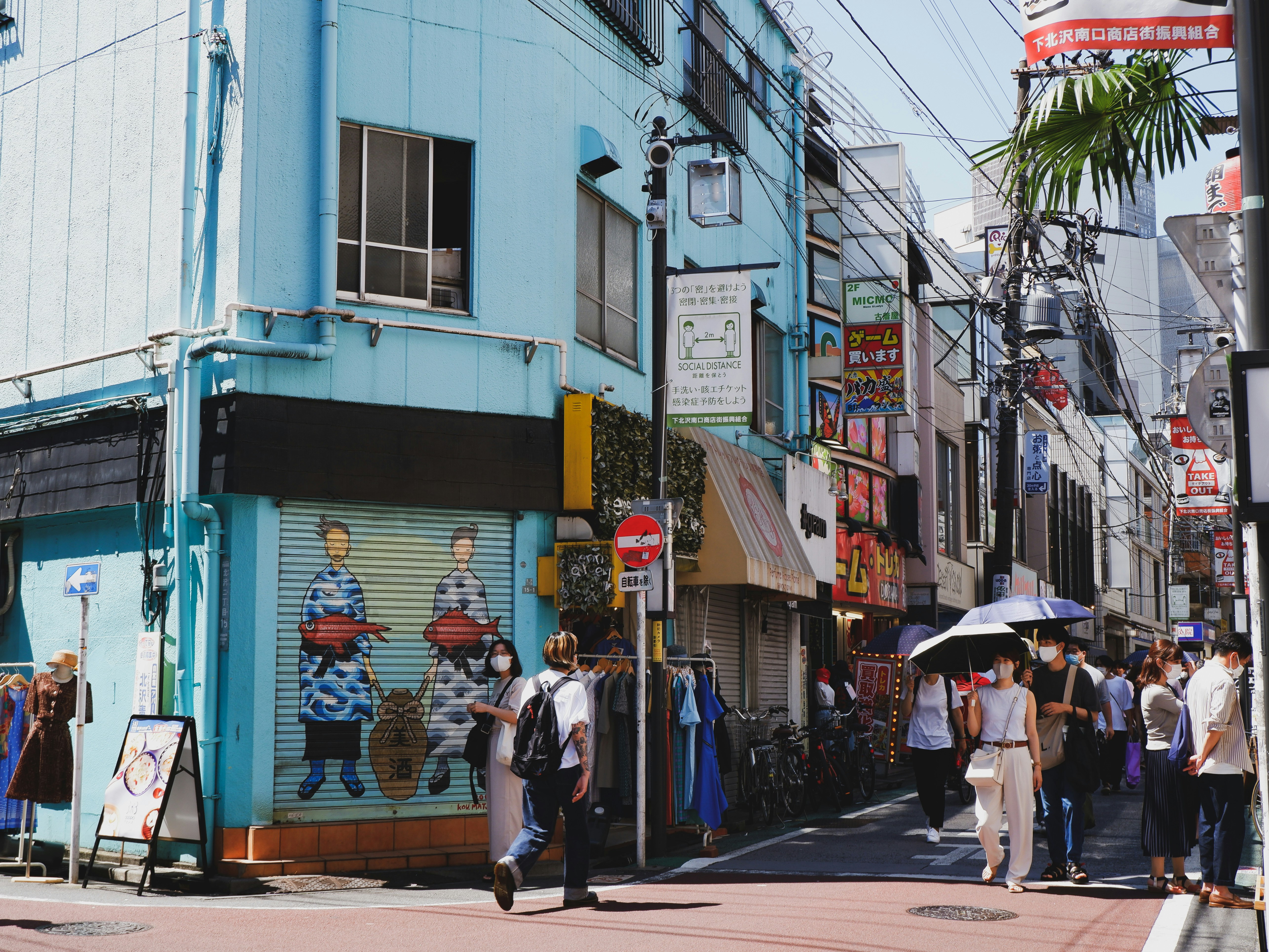 a group of people walking down a street next to tall buildings, Shopping Street, Shimokitazawa