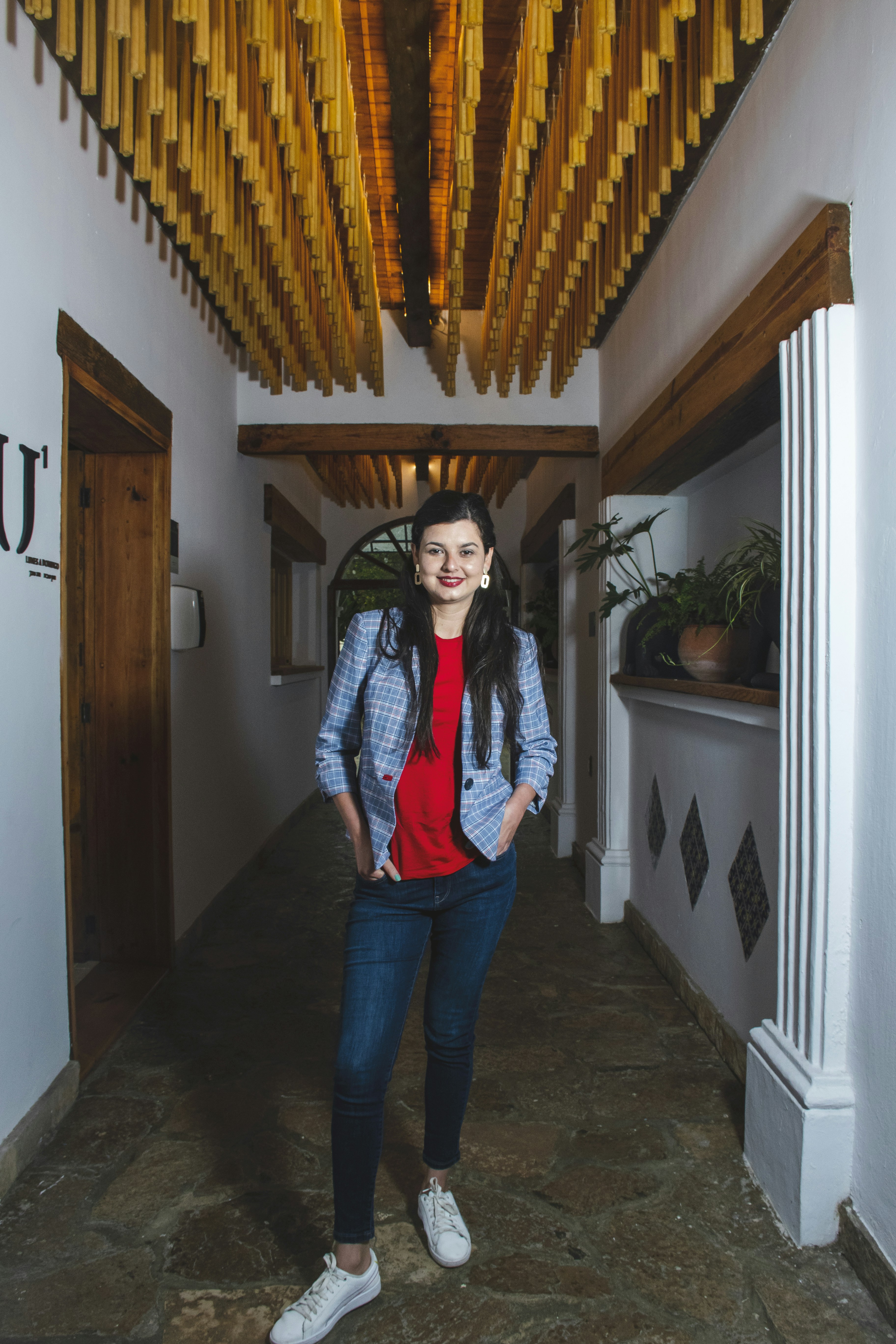 woman in blue denim jeans standing near brown wooden door