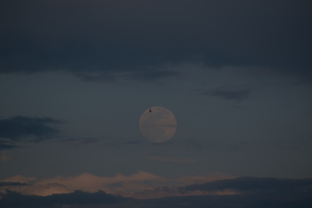 a full moon in the sky with clouds