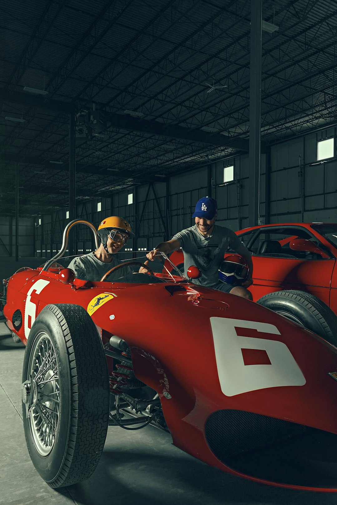 man in blue helmet riding red sports car