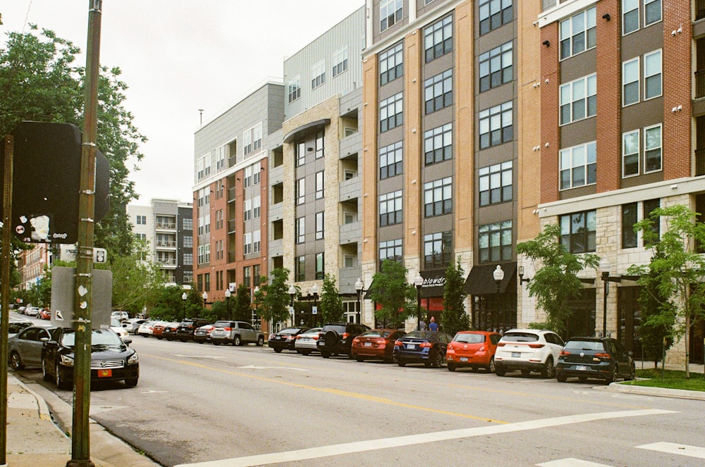 cars parked on side of the road near brown concrete building during daytime