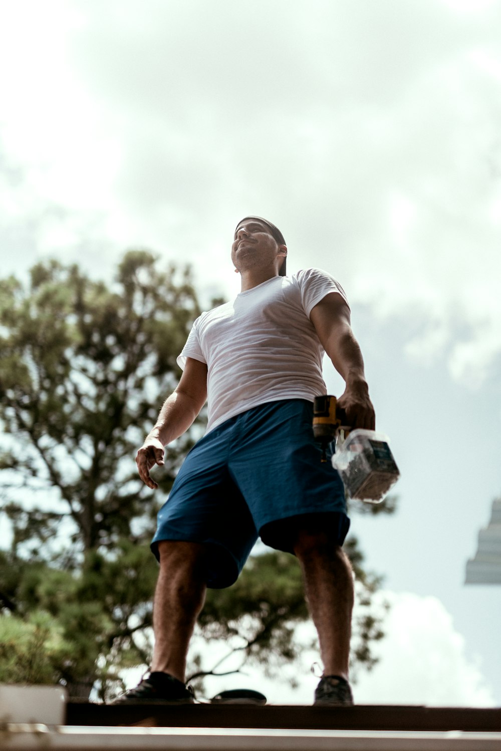 man in white t-shirt and blue shorts running on field