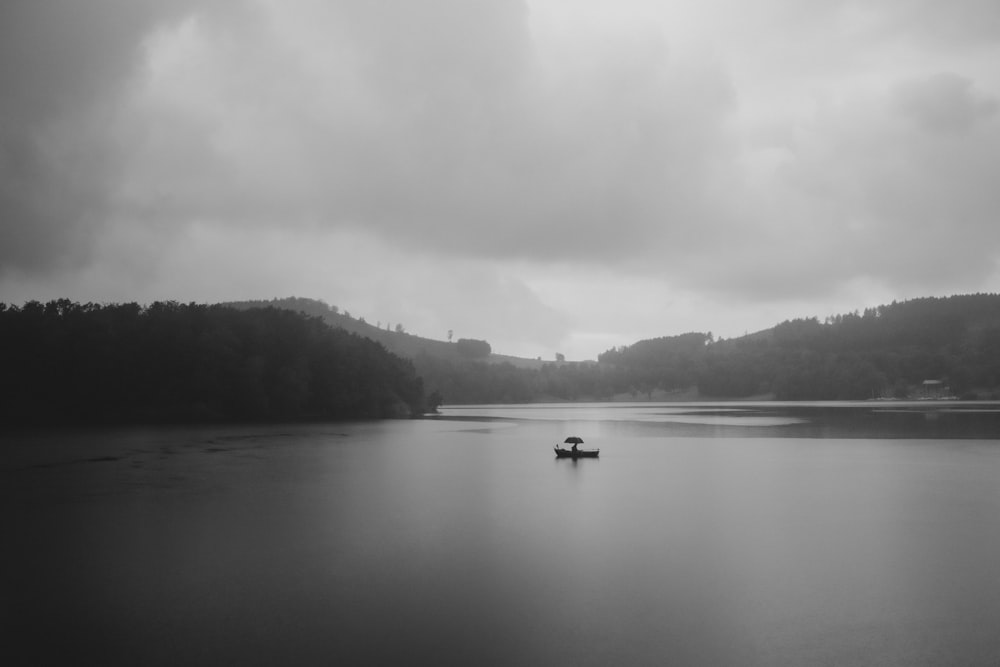 grayscale photo of boat on lake