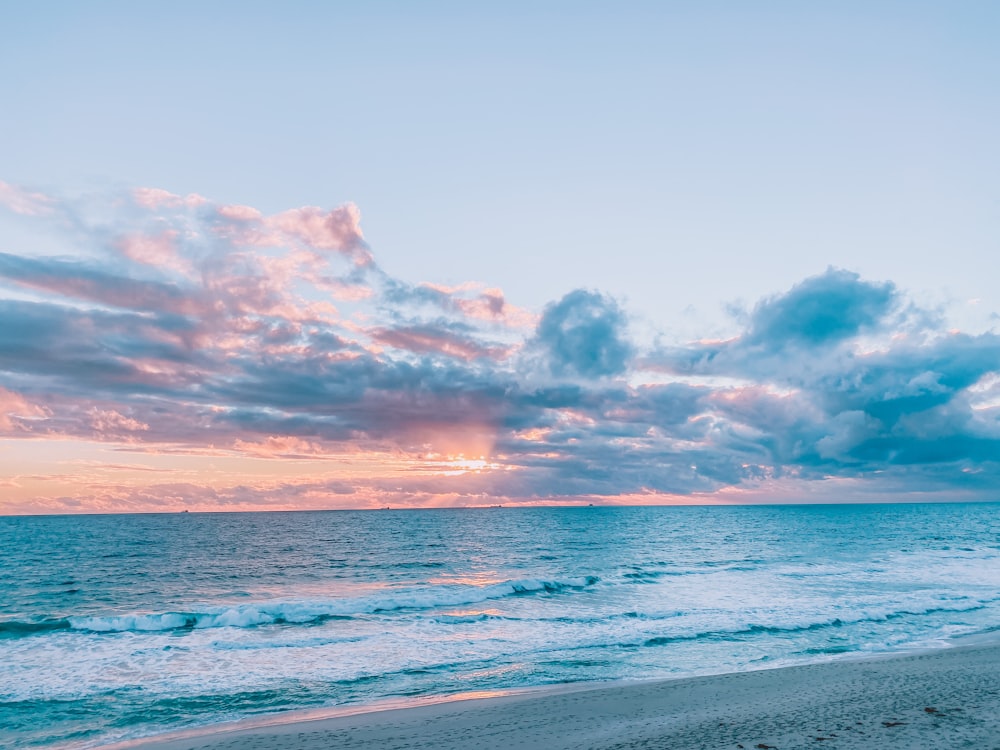 blue sea under blue sky and white clouds during daytime