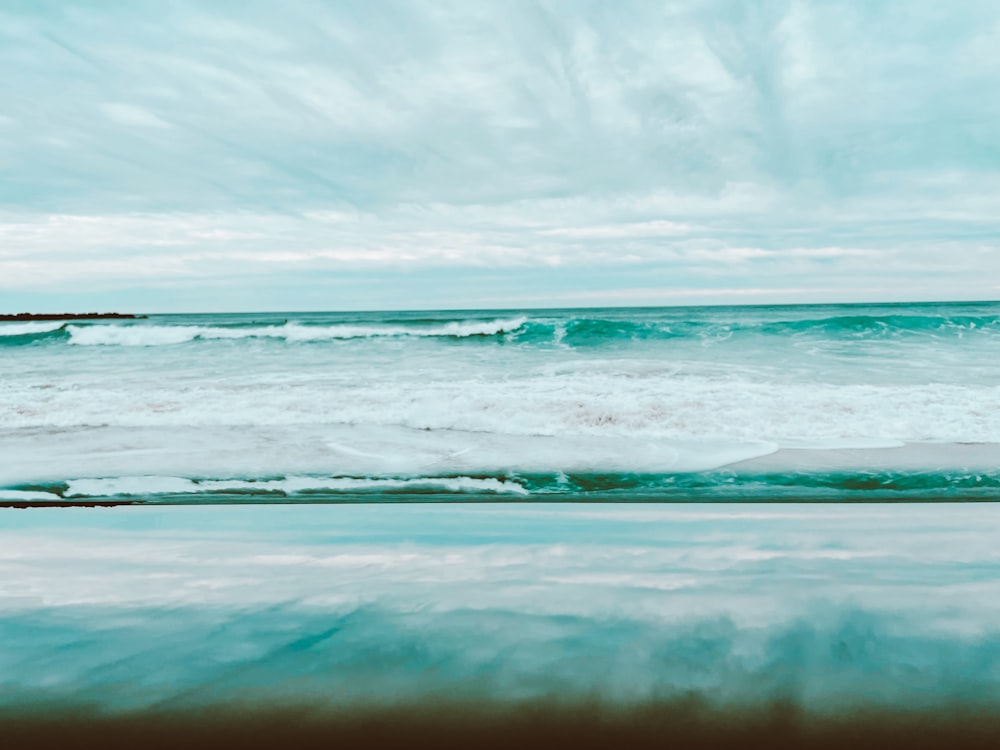 ocean waves under cloudy sky during daytime