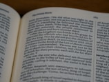 An open book displaying text in English with a focus on biblical content, including headings and body text on both visible pages.