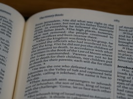 An open book displaying text in English with a focus on biblical content, including headings and body text on both visible pages.