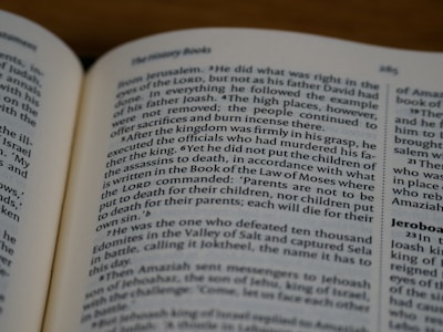 An open book displaying text in English with a focus on biblical content, including headings and body text on both visible pages.