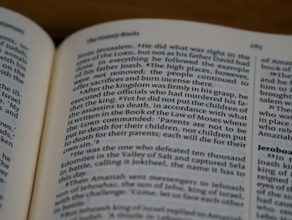 An open book displaying text in English with a focus on biblical content, including headings and body text on both visible pages.