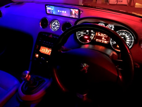 A striking blue sports car dashboard illuminated with futuristic digital displays.