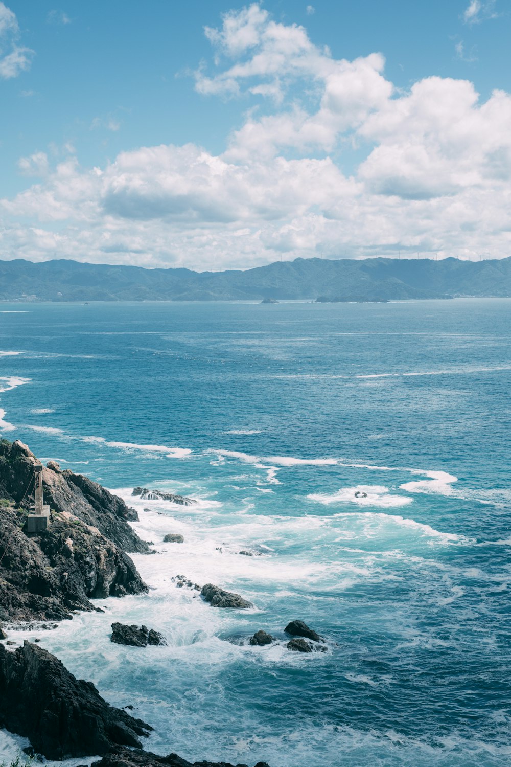 ocean waves crashing on rocky shore during daytime