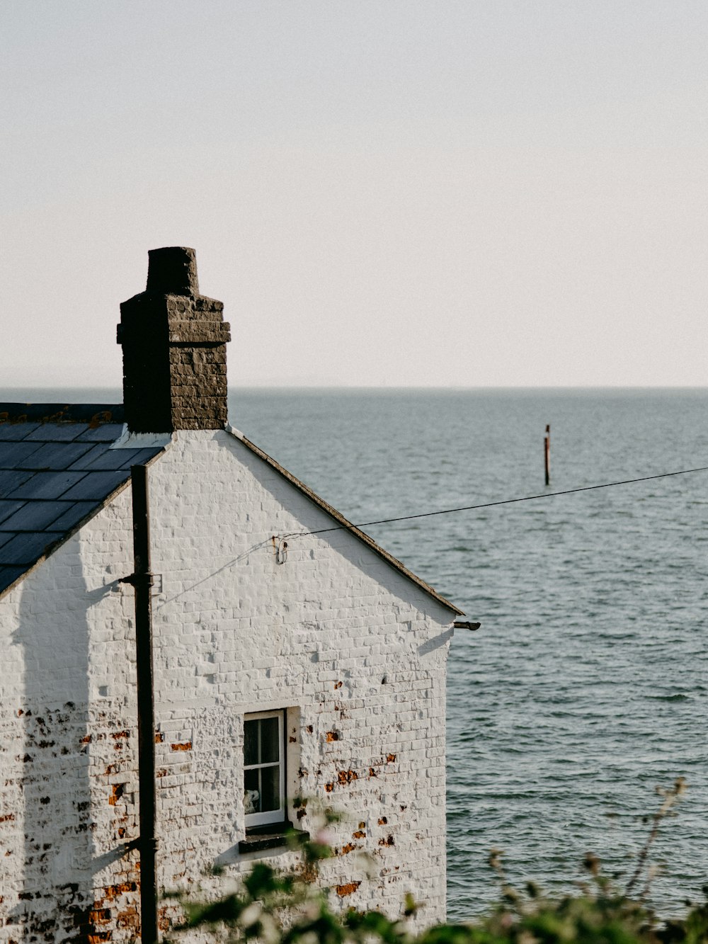 white and black concrete house near sea during daytime