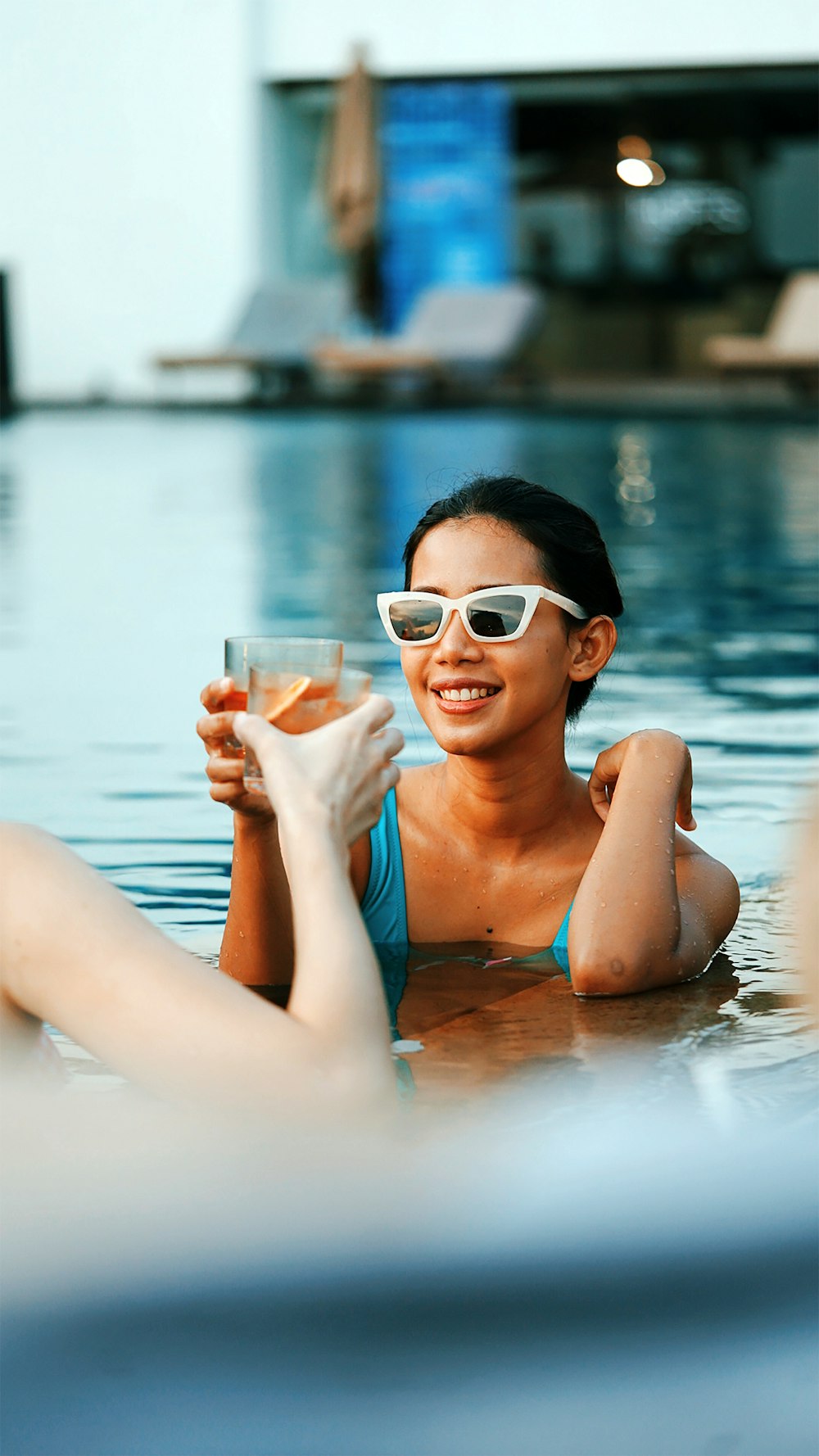 femme en débardeur bleu tenant un verre à boire