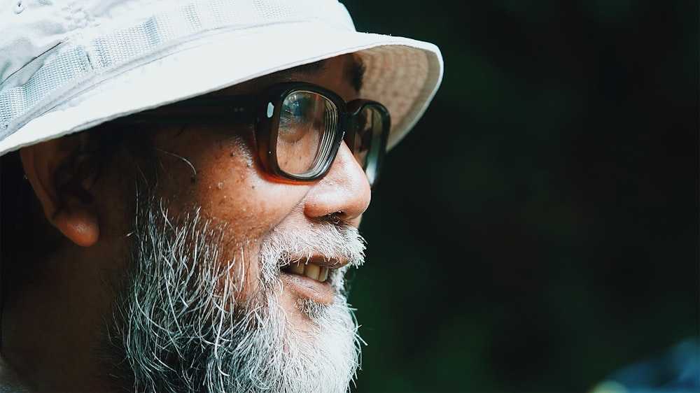 man in white hat and black framed eyeglasses