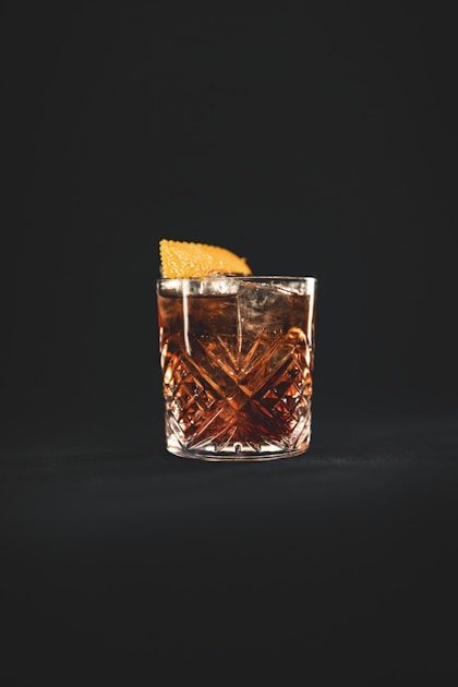 Verre tumbler d'amaro italien servi sur glace avec zeste d'orange en garniture